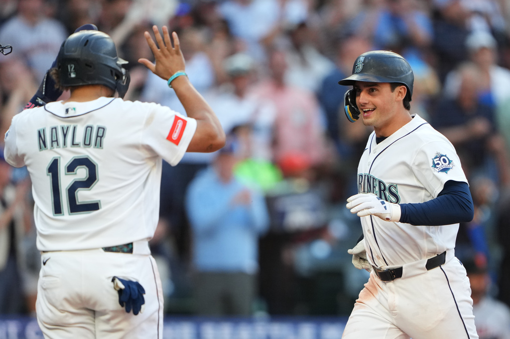 Seattle Mariners' Cole Young, right, is greeted by Josh Naylor (12) after hitting a three-run home run against the San Francisco Giants during the seventh inning of a baseball game, Saturday, July 18, 2026, in Seattle. (AP Photo/Lindsey Wasson)