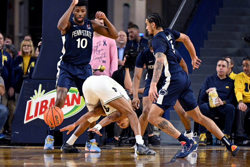 Michigan guard Nimari Burnett (4) looses control of the ball between his legs whiles driving to the basket against Penn State forward Josh Reed (10) and Penn State guard Freddie Dilione V (5) in the first half of an NCAA college basketball game in Ann Arbor, Mich., Thursday, Feb. 5, 2026. (AP Photo/Lon Horwedel)