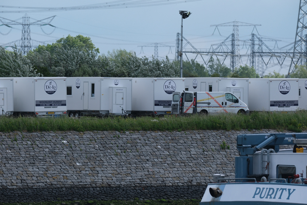 White container units are on the quayside as the MV Hondius cruise ship arrives at the Port of Rotterdam, Netherlands, Monday, May 18, 2026. (AP Photo/Patrick Post)