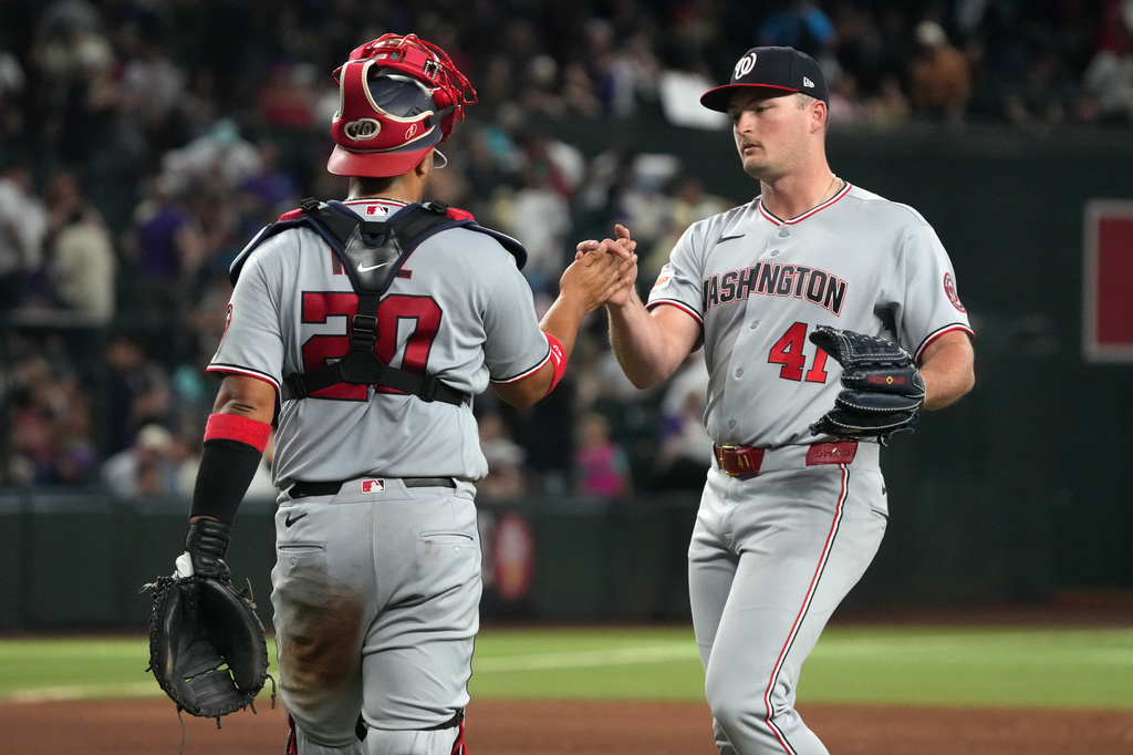 Washington Nationals catcher Keibert Ruiz, left, and pitcher Brad Lord, right, celebrate after their team defeated the Arizona Diamondbacks in a baseball game, Saturday, June 6, 2026, in Phoenix. (AP Photo/Rick Scuteri)