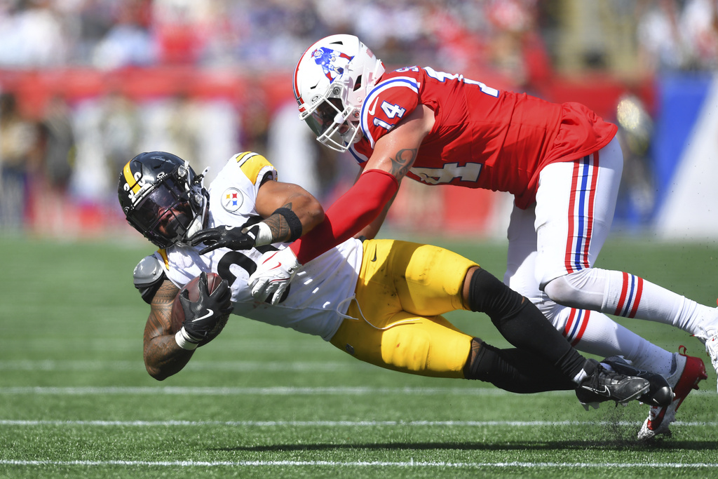 New England Patriots linebacker Robert Spillane (14) tackles Pittsburgh Steelers running back Jaylen Warren (30) during the first half of an NFL football game, Sunday, Sept. 21, 2025, in Foxborough, Mass. (AP Photo/Steven Senne)