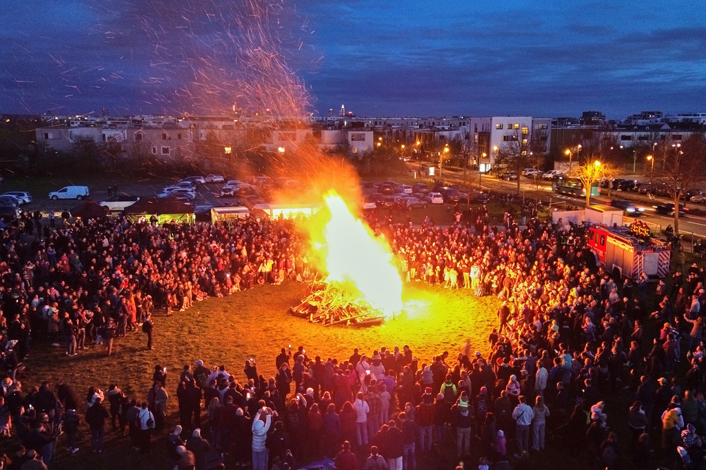People attend a traditional Easter fire, a traditional bonfire lit on Holy Saturday symbolizing the resurrection of Jesus Christ, in Frankfurt, Germany, Saturday, April 4, 2026. (AP Photo/Michael Probst)