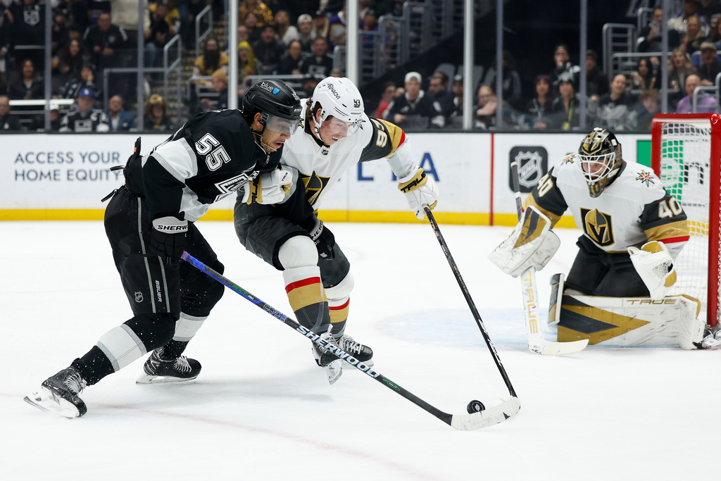 Los Angeles Kings right wing Quinton Byfield (55) and Vegas Golden Knights right wing Mitch Marner (93) fight for possession of the puck during the second period of an NHL hockey game Wednesday, Jan. 14, 2026, in Los Angeles. (AP Photo/Caroline Brehman)