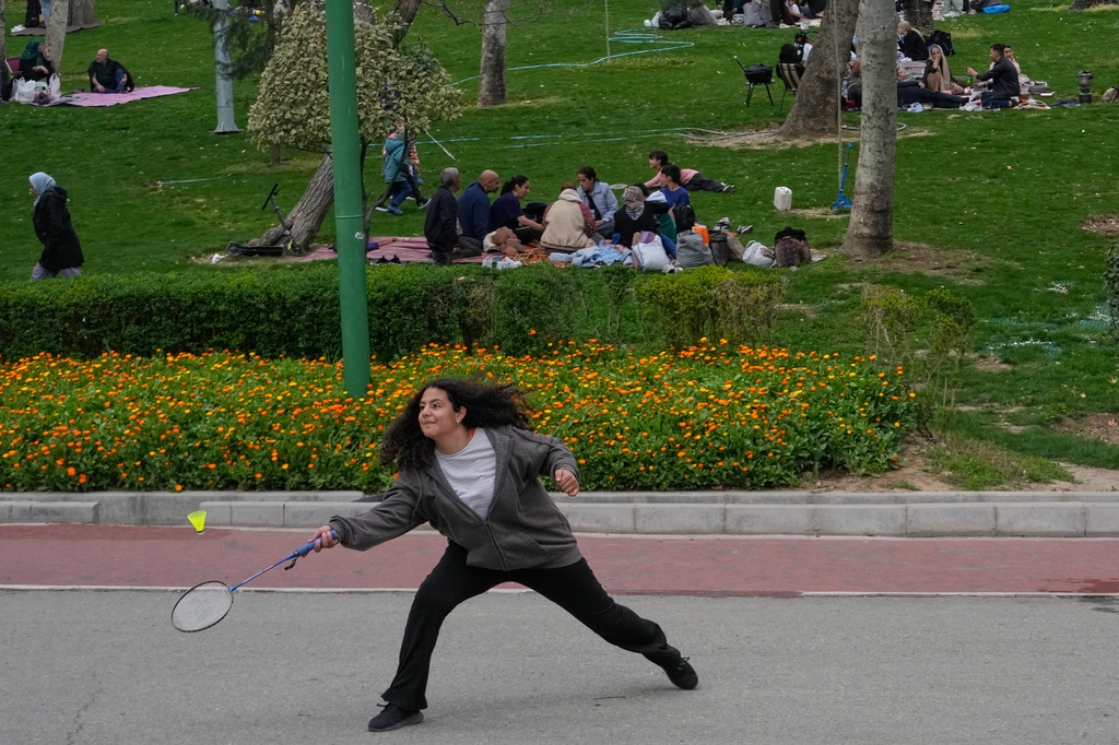 A girl plays badminton during the annual public picnic day, known as Sizdeh Bedar, an ancient tradition, marking the 13th and last day of Iranian New Year, or Nowruz, holidays, at Mellat park in Tehran, Iran, Thursday, April 2, 2026. (AP Photo/Vahid Salemi)