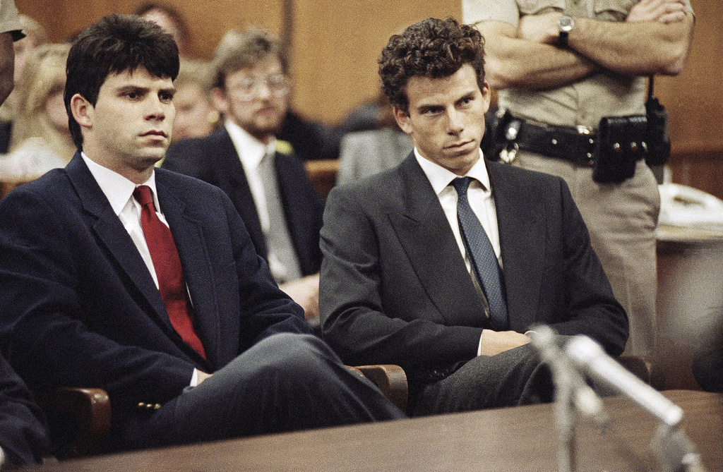 FILE - Lyle, left, and Erik Menendez sit in Beverly Hills Municipal Court where their attorneys delayed making pleas on their behalf in Beverly Hills, Calif., March 12, 1990. (AP Photo/Nick Ut, File)