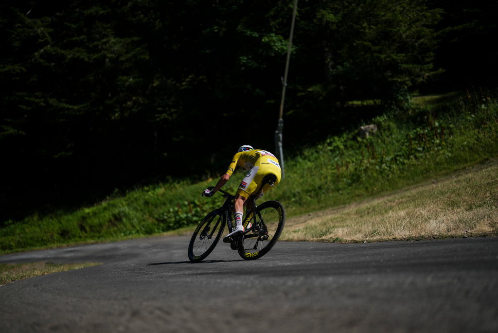 Slovenia's Tadej Pogacar, wearing the overall leader's yellow jersey, speeds towards the final stage of the tenth stage of the Tour de France cycling race with start in Aurillac and finish in Le Lioran, France, Tuesday, July 14, 2026. (AP Photo/Thibault Camus)