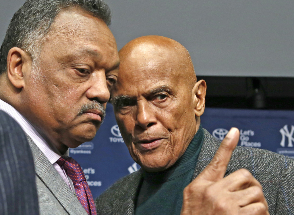 FILE - Rev. Jesse Jackson, left, talks with singer and civil right rights activist Harry Belafonte after a news conference announcing the installation of a Nelson Mandela plaque in Yankee Stadium's Monument Park in New York, April 16, 2014. (AP Photo/Kathy Willens, File)