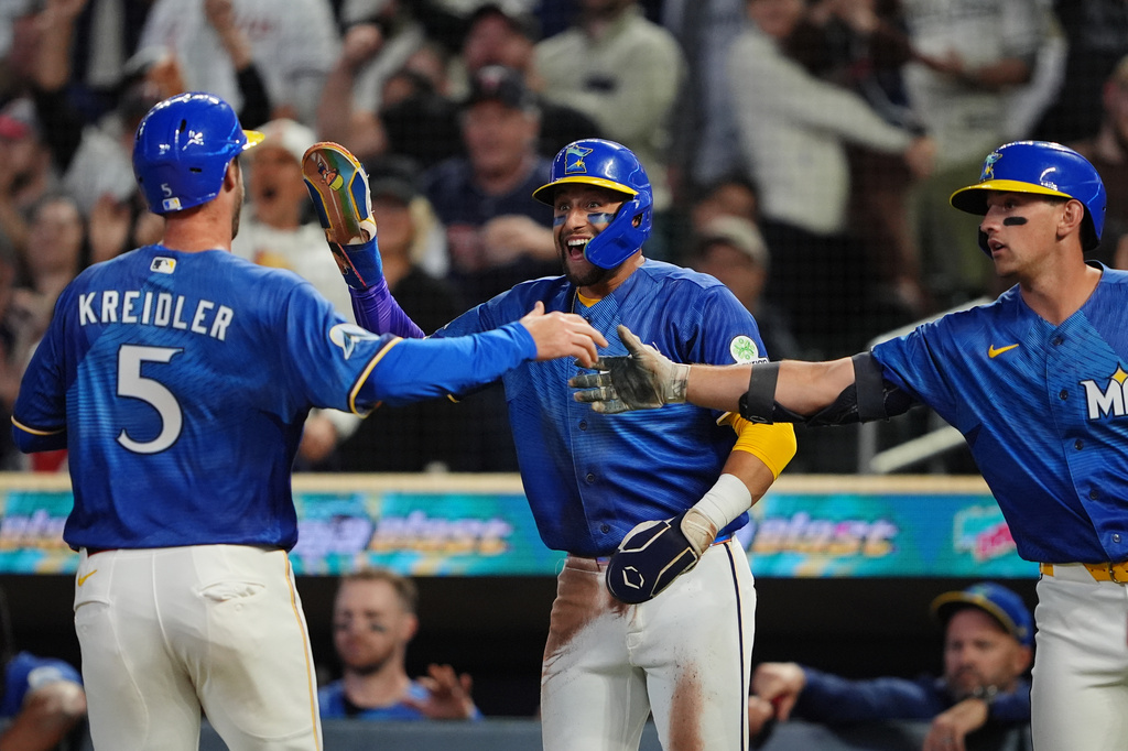 Minnesota Twins' Ryan Kreidler (5), Royce Lewis, center, Brooks Lee, right, celebrate after they scored during the second inning of a baseball game against the Texas Rangers, Friday, Sept. 25, 2026, in Minneapolis. (AP Photo/Ellen Schmidt)