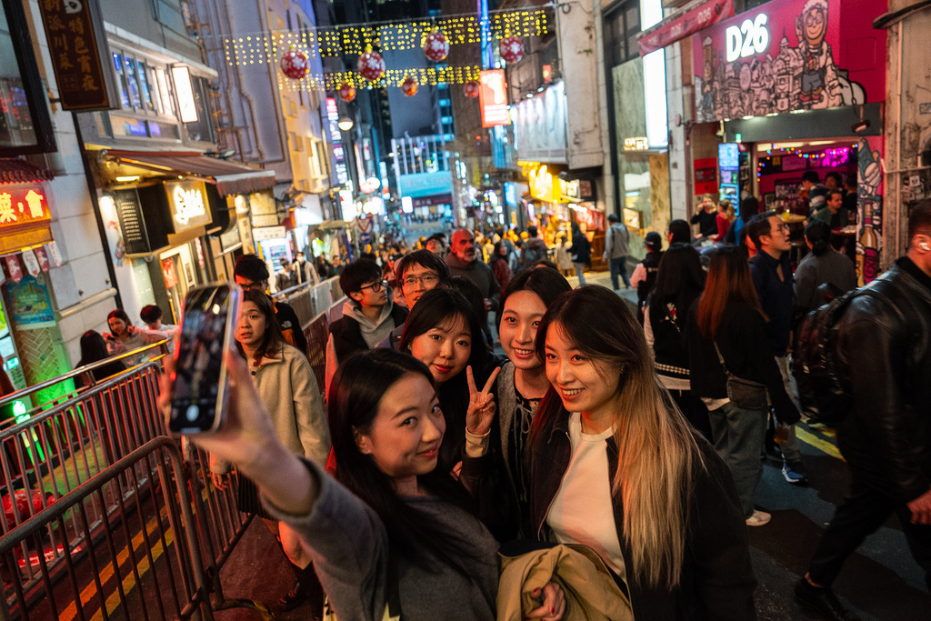 People take selfies at Lan Kwai Fong to celebrate the start of 2026 in the Central district of Hong Kong, on Wednesday, Dec. 31, 2025. (AP Photo/Chan Long Hei)