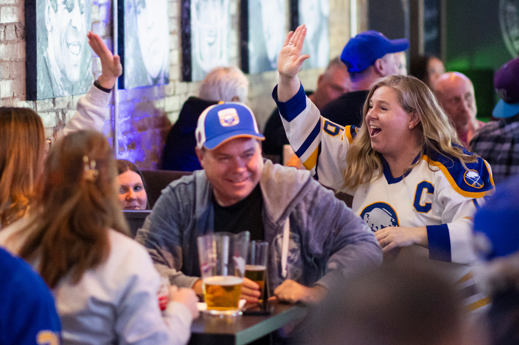 Buffalo Sabres fans celebrate a goal while watching Stanley Cup second-round playoff action against the Montreal Canadiens at Kully's Original Sports Bar in St. Catharines, on Wednesday, May 6, 2026. (Nick Iwanyshyn/The Canadian Press via AP)