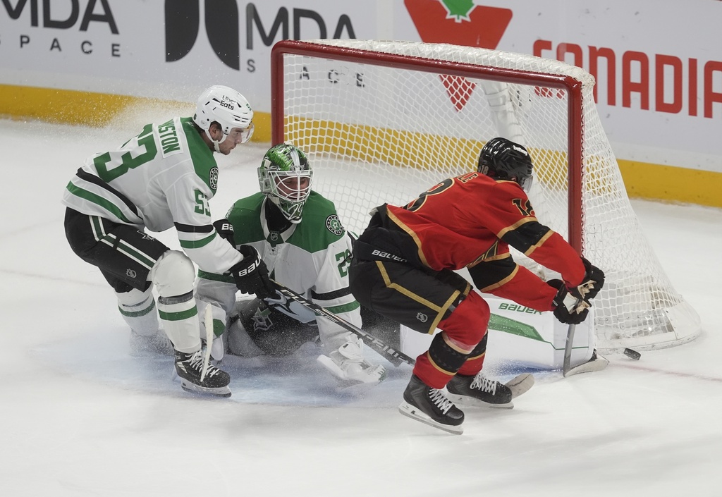 Dallas Stars goaltender Jake Oettinger stops Ottawa Senators center Tim Stutzle as he is chased by Dallas Stars center Wyatt Johnston during overtime of an NHL hockey game in Ottawa, Tuesday, Nov. 11, 2025. (Adrian Wyld/The Canadian Press via AP)