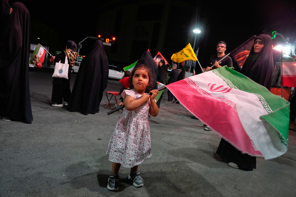 A girl waves an Iranian flag in a pro-government gathering commemorating the late Iranian Supreme Leader Ayatollah Ali Khamenei at a square in Tehran, Saturday, July 11, 2026. (AP Photo/Vahid Salemi)
