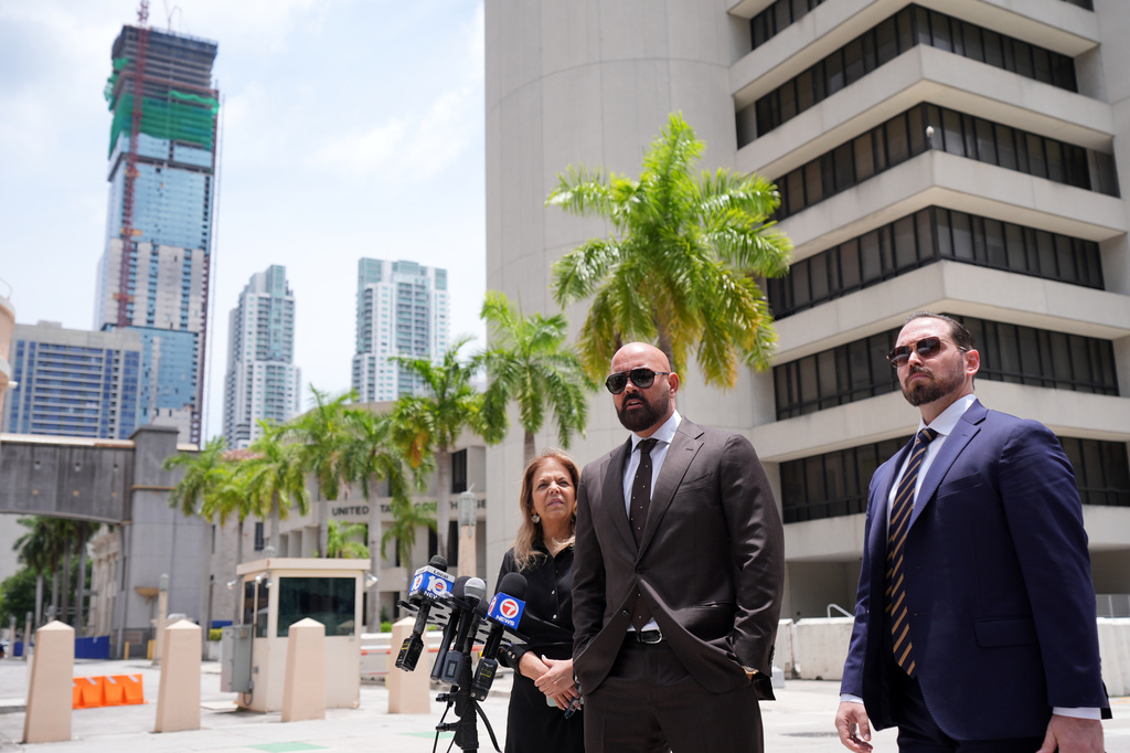Attorneys Joseph McBride, center, and Jackie Perczek, left, representing Andrew and Tristan Tate as they fight extradition to the United Kingdom, where they are accused of rape and sex trafficking, speak to the media outside the C. Clyde Atkins U.S. Courthouse, Monday, July 27, 2026, in Miami. (AP Photo/Rebecca Blackwell)