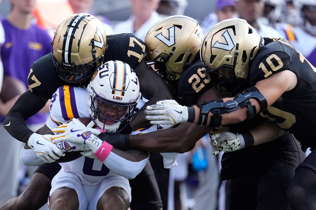 LSU wide receiver Zavion Thomas (0) is tackled by Vanderbilt cornerback Mark Davis (17), defensive end Miles Capers (29) and linebacker Langston Patterson (10) during the second half of an NCAA college football game Saturday, Oct. 18, 2025, in Nashville, Tenn. (AP Photo/George Walker IV)