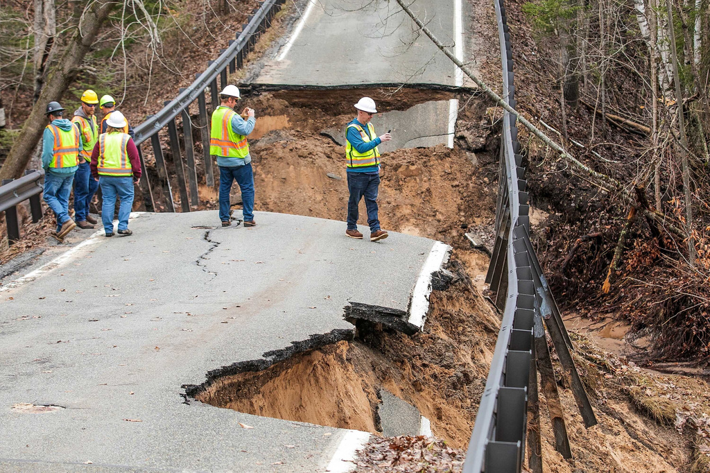 A team from the Michigan Department of Transportation inspects a washed-out bridge on M-119 between Division and Island View Roads, south of Cross Village, Mich., in Emmett County on Monday, April 13, 2026. (Jan-Michael Stump/Traverse City Record-Eagle via AP)