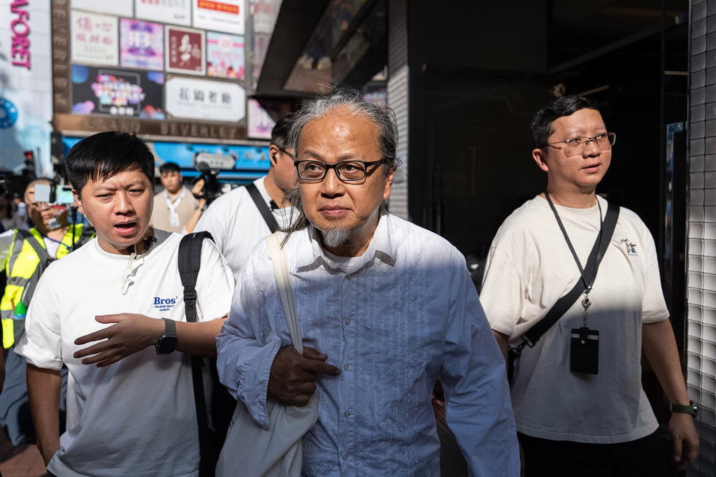 Police officers escort artist Sanmu Chen in the Causeway Bay area on the eve of the 37th anniversary of China's Tiananmen Square crackdown in Hong Kong, Wednesday, June 3, 2026. (AP Photo/Chan Long Hei)