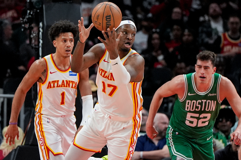 Atlanta Hawks forward Onyeka Okongwu (17) grabs a loose ball against Boston Celtics center Luka Garza (52) in the first half of an NBA basketball game, Monday, March 30, 2026, in Atlanta. (AP Photo/Mike Stewart)