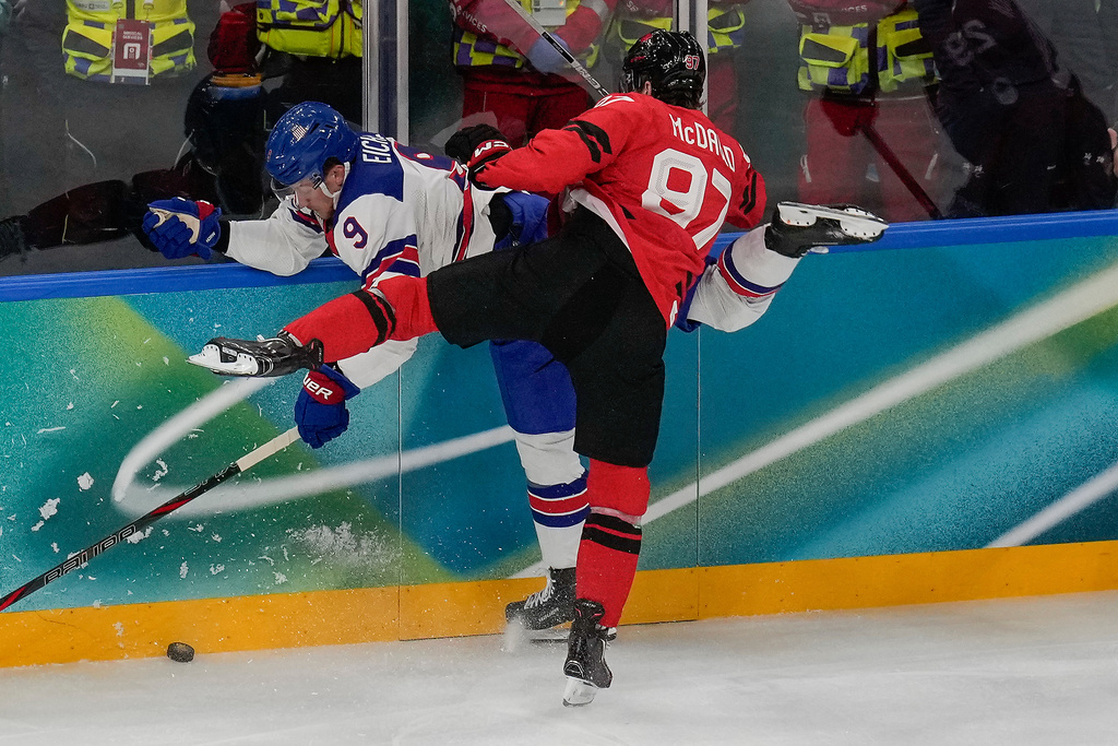 Canada's Connor McDavid (97) checks United States' Jack Eichel (9) into the wall during the first period of the men's ice hockey gold medal game at the 2026 Winter Olympics, in Milan, Italy, Sunday, Feb. 22, 2026. (AP Photo/Luca Bruno)