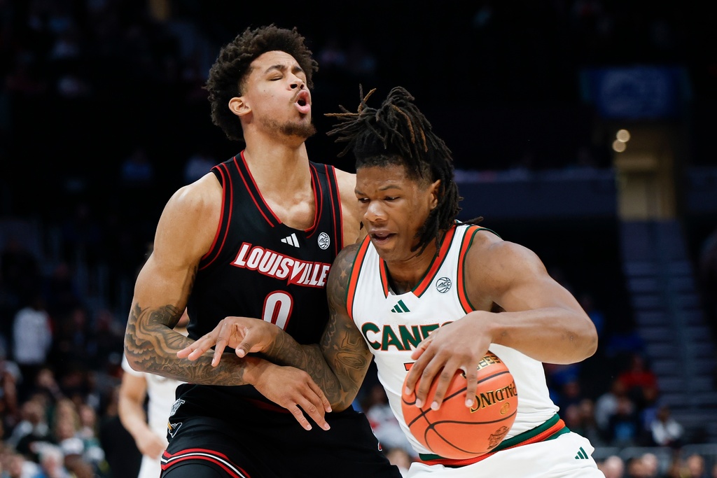 Miami forward Shelton Henderson, right, drives into Louisville forward Khani Rooths during the first half of an NCAA college basketball game in the quarterfinals of the Atlantic Coast Conference tournament in Charlotte, N.C., Thursday, March 12, 2026. (AP Photo/Nell Redmond)