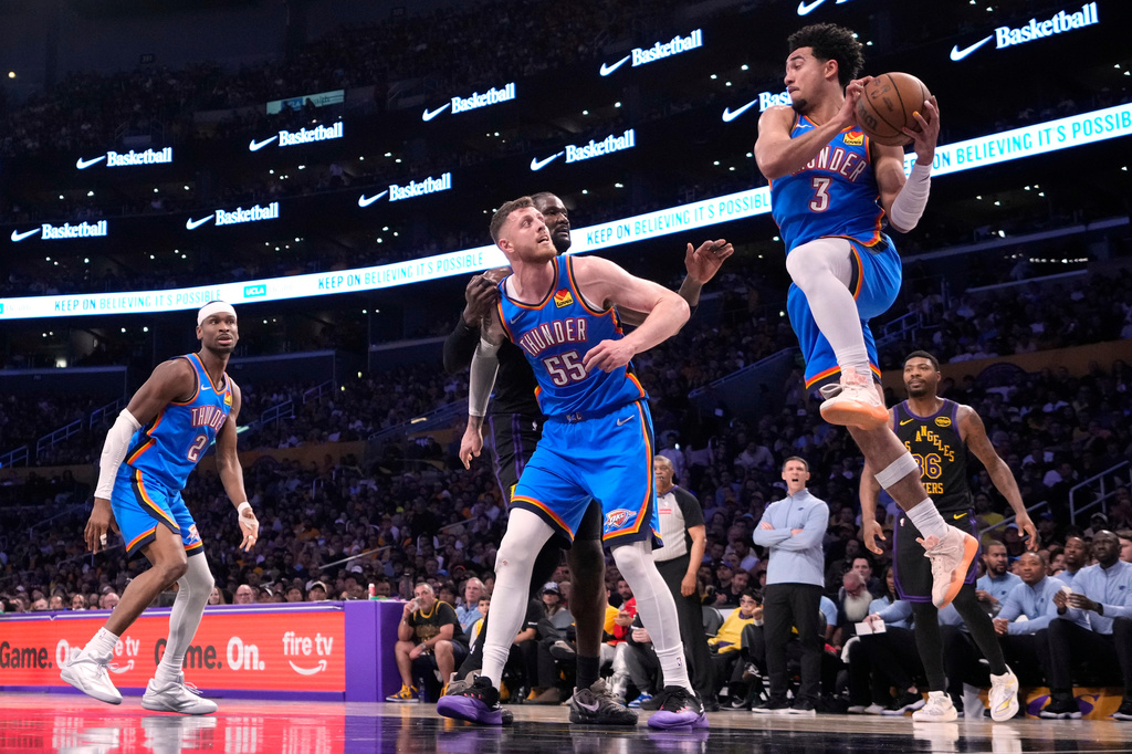 Oklahoma City Thunder guard Jared McCain, second from right, passes the ball as guard Shai Gilgeous-Alexander, left, center Isaiah Hartenstein, second from left, Los Angeles Lakers center Deandre Ayton, center, and guard Marcus Smart, right, watch during the first half of Game 4 in a second-round NBA basketball playoffs series Monday, May 11, 2026, in Los Angeles. (AP Photo/Mark J. Terrill)