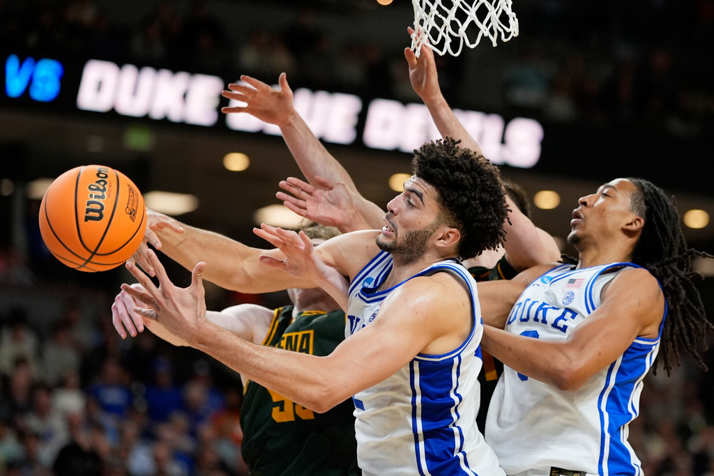 Duke forward Cameron Boozer vies for the ball with Siena center Riley Mulvey during the second half in the first round of the NCAA college basketball tournament, Thursday, March 19, 2026, in Greenville, S.C. (AP Photo/Chris Carlson)