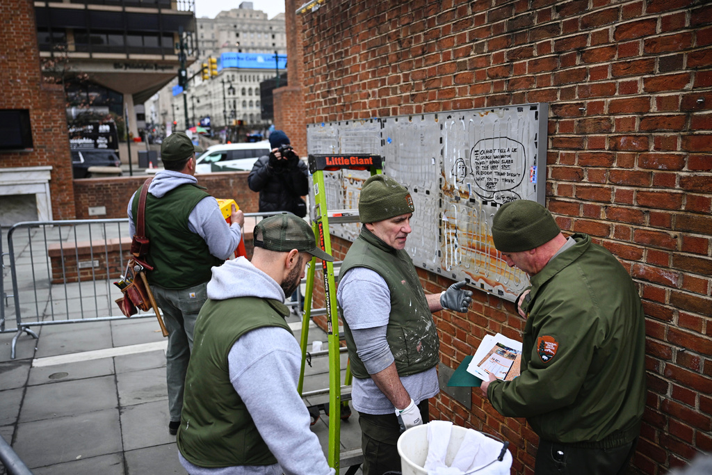 National Parks Service workers talk as panels that were part of an exhibit on slavery at the President's House Site in Philadelphia are put back Thursday, Feb. 19, 2026. (AP Photo/Joe Lamberti)