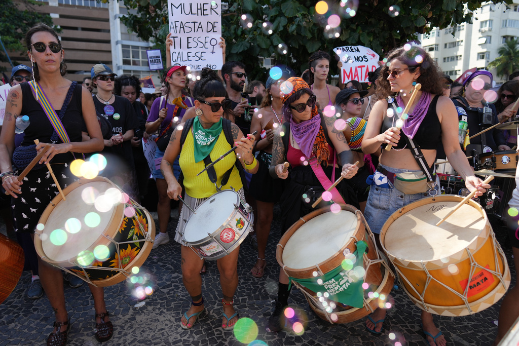 Women protest femicide following a series of high-profile cases in the country, on Copacabana beach, Rio de Janeiro, Sunday, Dec. 7, 2025. (AP Photo/Silvia Izquierdo)