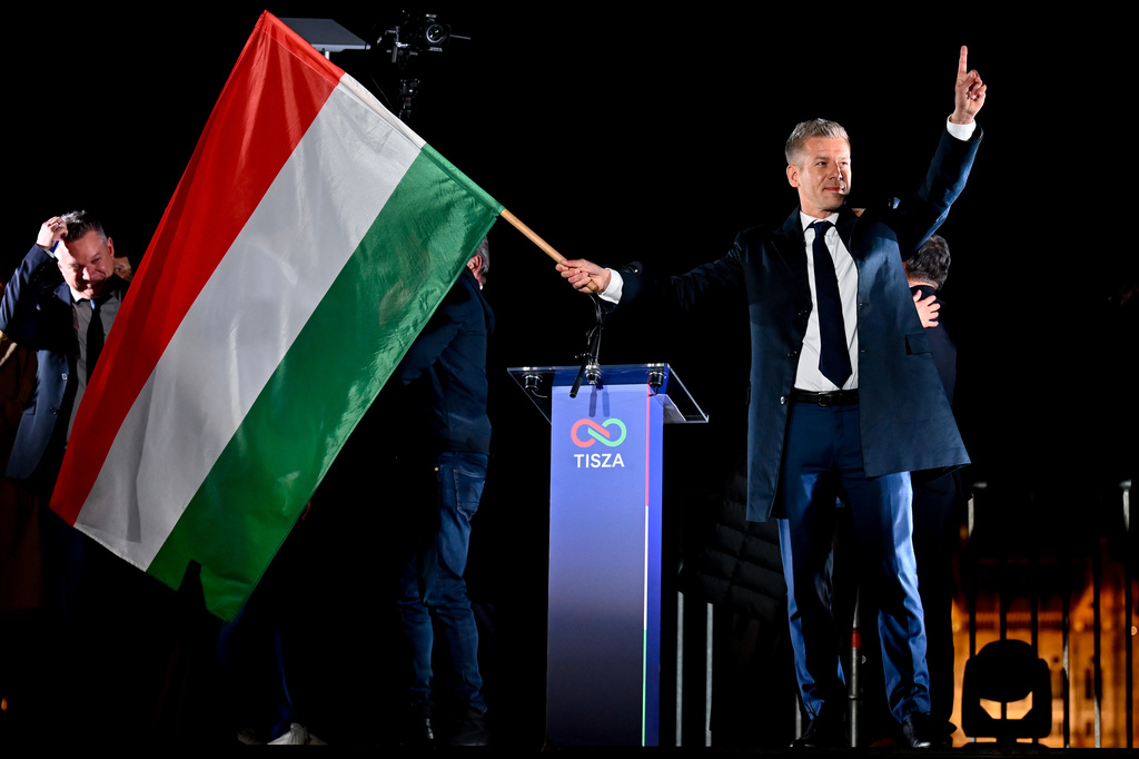 Peter Magyar, leader of the opposition Tisza party, waves the Hungarian flag following the announcement of the partial results of the parliamentary election, in Budapest, Hungary, Sunday, April 12, 2026. (AP Photo/Denes Erdos)