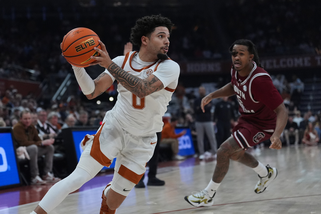 Texas guard Jordan Pope (0) drives past South Carolina guard Meechie Johnson (5) during the second half of an NCAA college basketball game in Austin, Texas, Feb. 3, 2026. (AP Photo/Eric Gay)