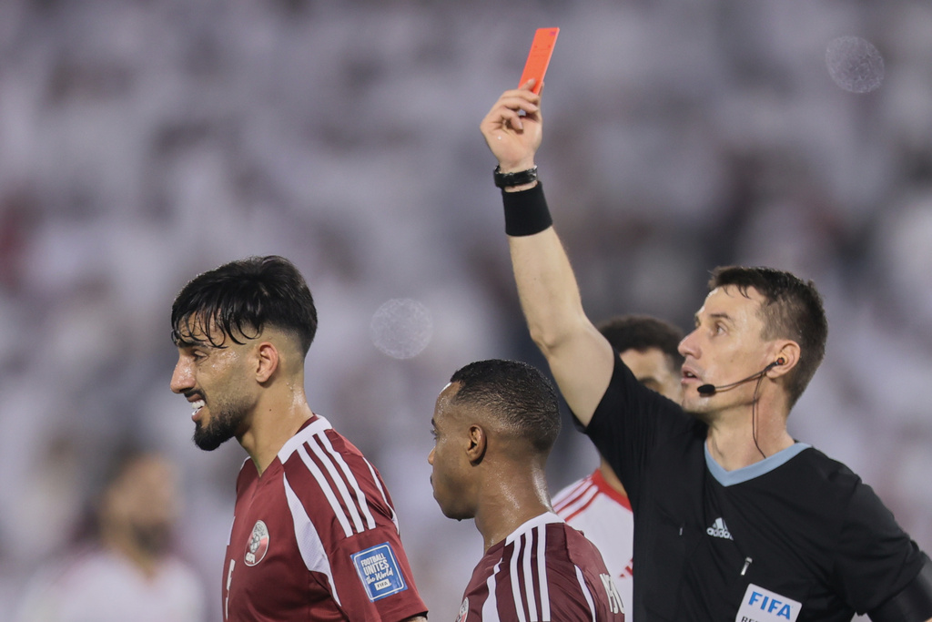 The referee shows a red card to Qatar's Tarek Salman, left, during the 2026 World Cup qualifying soccer match between Qatar and the United Arab Emirates at the Hamad Bin Jassim Stadium in Doha on Tuesday, Oct. 14, 2025. (AP Photo/Hussein Sayed)