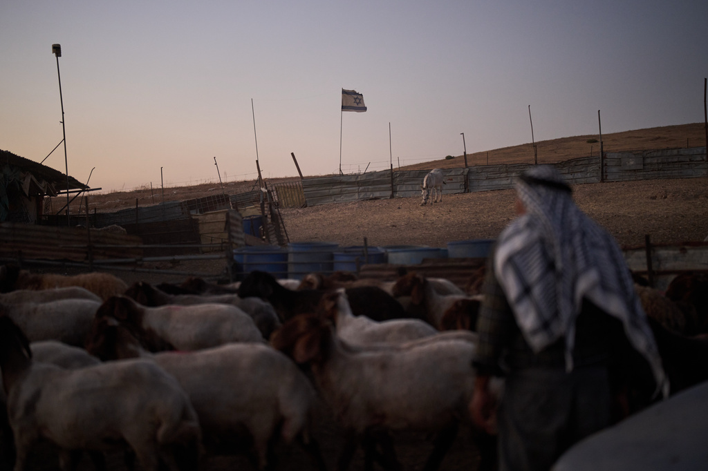 An Israeli flag, set up by settlers, waves beside a fence around a Palestinian compound's sheep pen at dusk in the northern Jordan Valley in the occupied West Bank, Tuesday, June 23, 2026.(AP Photo/Leo Correa)