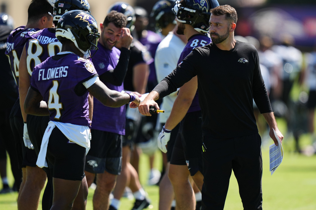 Baltimore Ravens offensive coordinator Declan Doyle, right, bumps fists with wide receiver Zay Flowers (4) during practice at the team's NFL football training camp, Thursday, July 30, 2026, at the Under Armour Performance Center in Owings Mills, Md. (AP Photo/Stephanie Scarbrough)