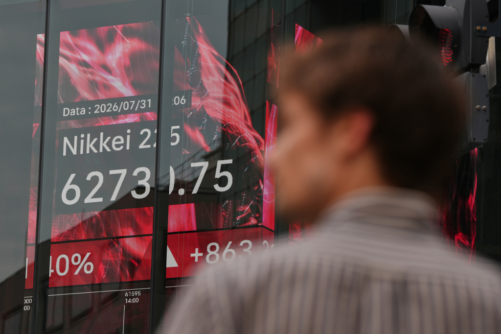 A person stands near an electronic board showing Japan's Nikkei index at a securities firm Friday, July 31, 2026. (AP Photo/Eugene Hoshiko)