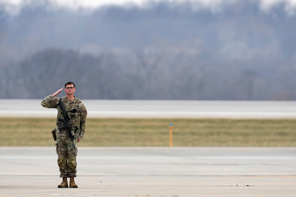 An Iowa National Guard member salutes as the remains of Staff Sgt. Edgar Brian Torres-Tovar, 25, of Des Moines, and Staff Sgt. William Nathaniel Howard, 29, of Marshalltown, the two Iowa National Guard members killed in an attack in the Syrian desert, are moved during a dignified transfer at the Des Moines International Airport in Des Moines, Iowa, Wednesday, Dec. 24, 2025. (AP Photo/Charlie Neibergall)