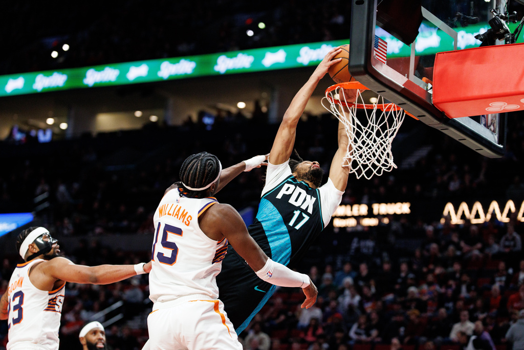 Portland Trail Blazers guard Shaedon Sharpe, right, dunks the ball against the Phoenix Suns during the second half of an NBA basketball game Tuesday, Feb. 3, 2026, in Portland, Ore. (AP Photo/Howard Lao)