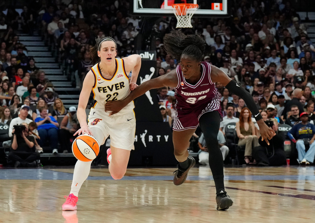 Indiana Fever's Caitlin Clark (22) drives as Toronto Tempo's Ornella Bankole (33) defends during the first half of a WNBA basketball game in Toronto on Tuesday, Aug. 18, 2026. (Chris Young/The Canadian Press via AP)