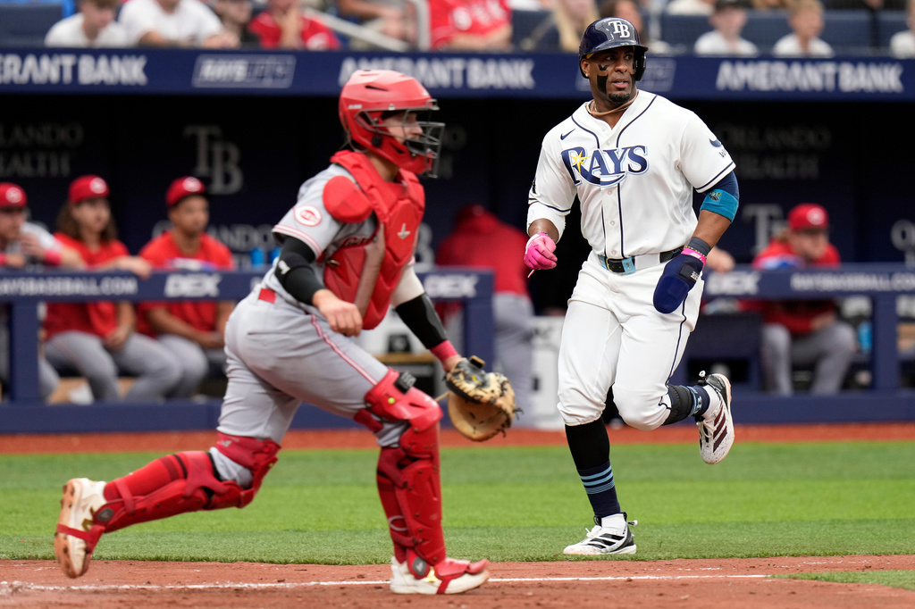 Tampa Bay Rays' Yandy Díaz, right, scores ahead of the throw to Cincinnati Reds catcher P.J. Higgins on an RBI single by Ryan Vilade during the fifth inning of a baseball game Wednesday, April 22, 2026, in St. Petersburg, Fla. (AP Photo/Chris O'Meara)