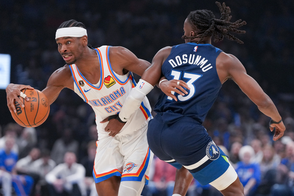 Oklahoma City Thunder Shai Gilgeous-Alexander, left, pushes past Minnesota Timberwolves guard Ayo Dosunmu, right, during the first half of an NBA basketball game, Sunday, March 15, 2026, in Oklahoma City. (AP Photo/Kyle Phillips)