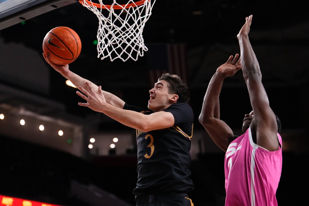 Northwestern forward Nick Martinelli, left, shoots as Southern California forward Ezra Ausar defends during the first half of an NCAA college basketball game Wednesday, Jan. 21, 2026, in Los Angeles. (AP Photo/Mark J. Terrill)