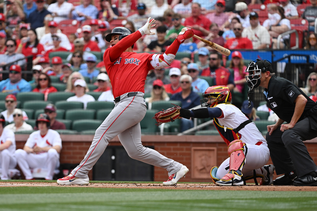 Boston Red Sox's Willson Contreras, left, hits a two-run home run in the first inning of a baseball game St. Louis Cardinals, Sunday, April 12, 2026, in St. Louis. (AP Photo/Michael Thomas)