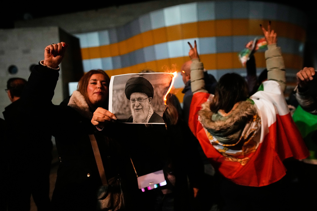 Demonstrators burn a poster depicting Iran's Supreme Leader Ayatollah Ali Khamenei during a rally in support of anti-government protests in Iran, in Holon, Israel Wednesday, Jan. 14, 2026. (AP Photo/Ohad Zwigenberg)