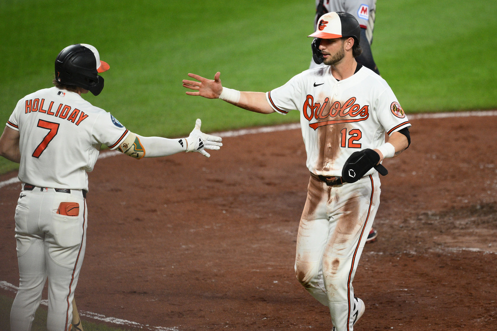 Baltimore Orioles' Dylan Beavers (12) is greeted by Jackson Holliday (7) after he scored when Christian Encarnacion-Strand was hit by a pitch by Cleveland Guardians pitcher Foster Griffin during the third inning of a baseball game, Wednesday, Sept. 9, 2026, in Baltimore. (AP Photo/Nick Wass)