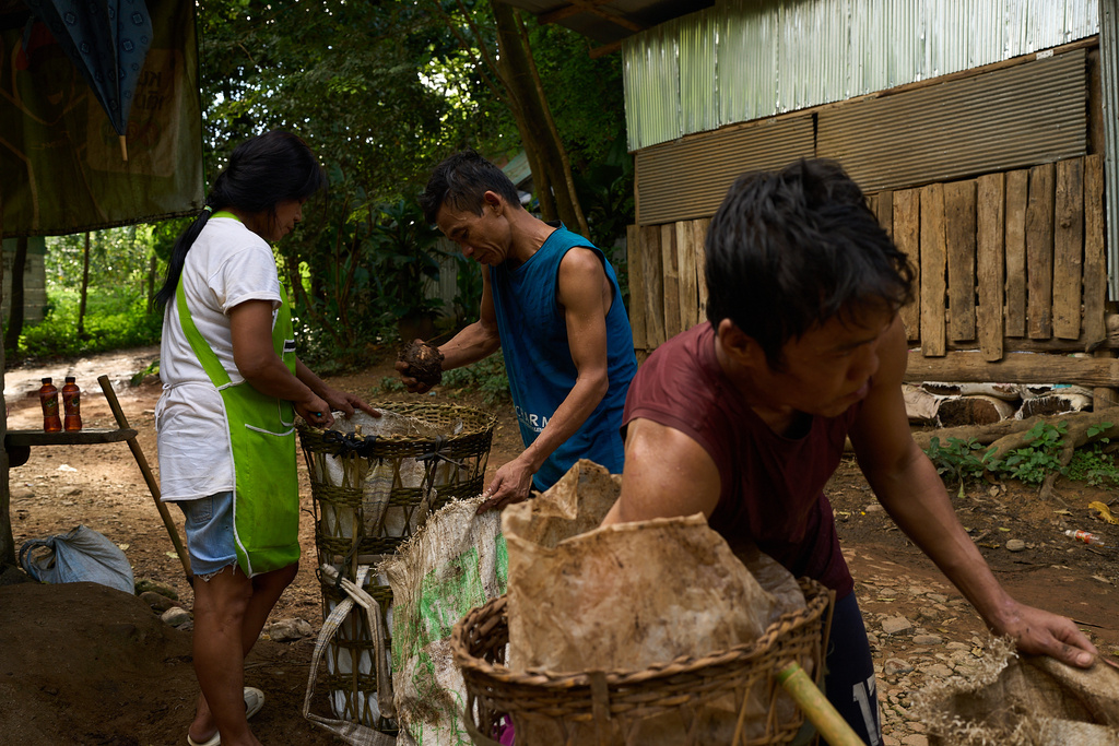 Two men sell yams they foraged in a forest near the Mae La refugee camp to a shop owner in the Tak province of Thailand, Wednesday, Aug. 27, 2025. (AP Photo/Bram Janssen)