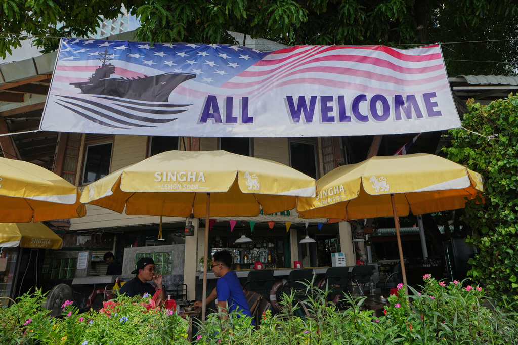 Customers of a restaurant sit under a banner in Pattaya, Thailand, on Sept. 1, 2026. (AP Photo/Sakchai Lalit)
