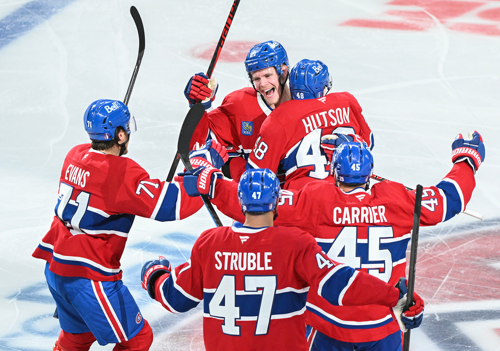 Montreal Canadiens' Lane Hutson (48) celebrates with teammate Kaiden Kuhle (21), Jake Evans (71), Jayden Struble (47) and Alexandre Carrier (45) after scoring against the Tampa Bay Lightning during overtime of Game 3 in a first-round NHL hockey Stanley Cup playoff series in Montreal, Friday, April 24, 2026. (Graham Hughes/The Canadian Press via AP)