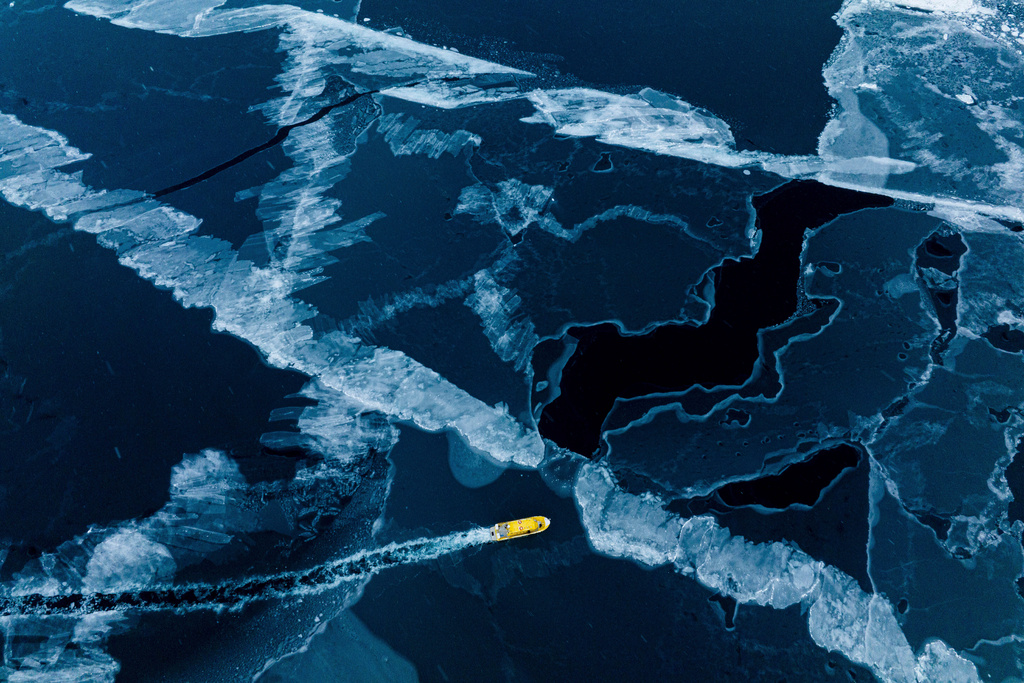 FILE - A boat rides though a frozen sea inlet outside of Nuuk, Greenland, on March 6, 2025. (AP Photo/Evgeniy Maloletka, File)