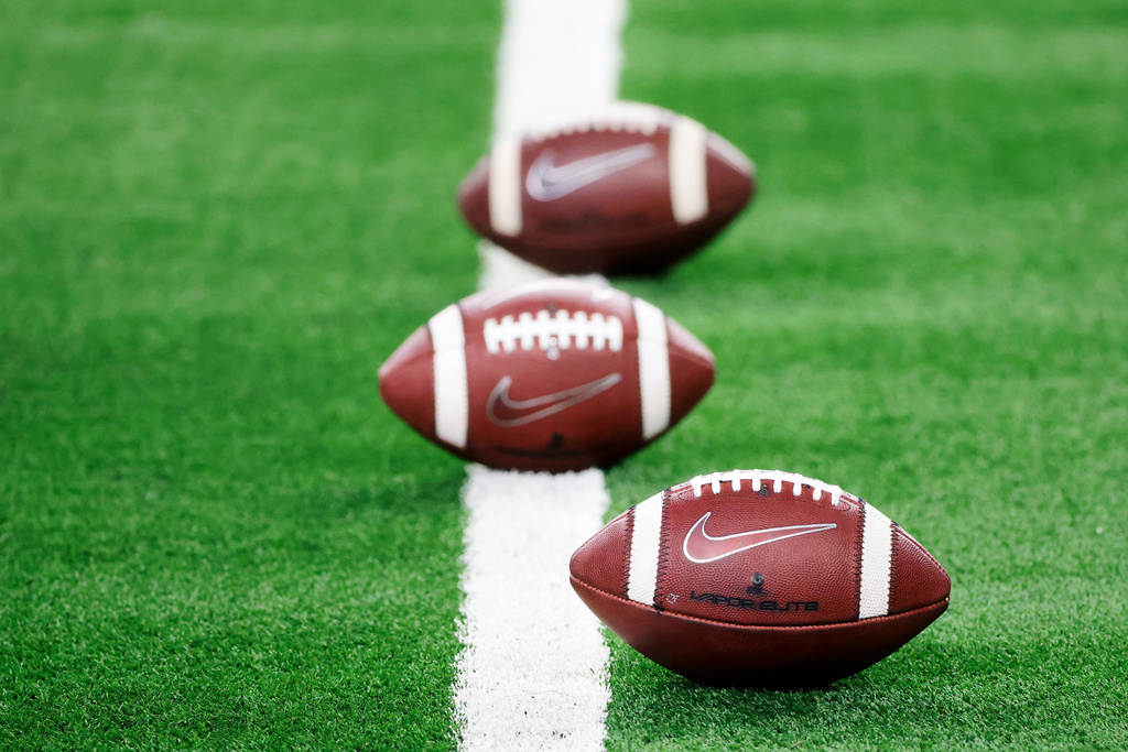FILE - Nike footballs on the field prior to the Rose Bowl NCAA college football game in Arlington, Texas, Friday, Jan. 1, 2021. (AP Photo/Michael Ainsworth, File)