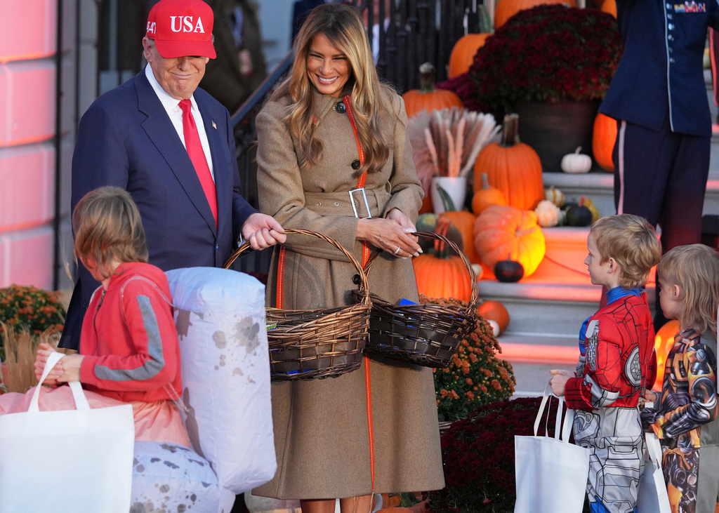 President Donald Trump, from left, and first lady Melania Trump greet families and hand out candy during a Halloween event on the South Lawn of the White House, Thursday, Oct. 30, 2025, in Washington. (AP Photo/Jacquelyn Martin)
