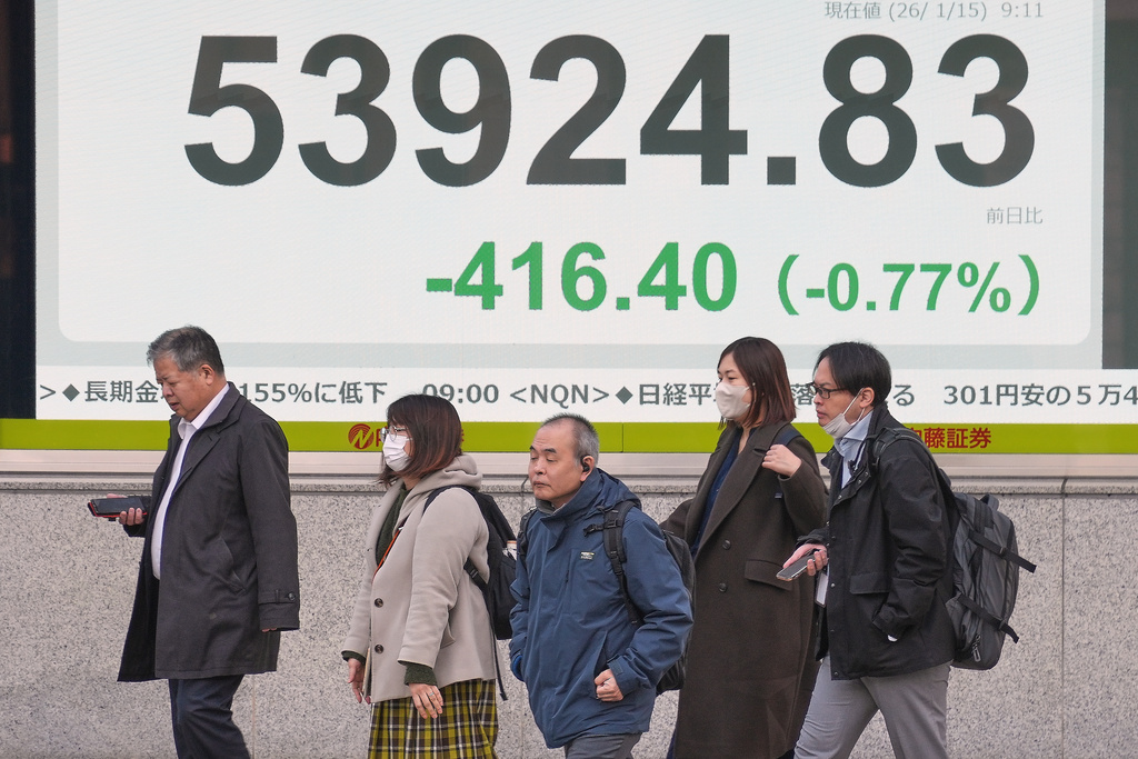 People walk in front of an electronic stock board showing Japan's Nikkei index at a securities firm Thursday, Jan. 15, 2026, in Tokyo. (AP Photo/Eugene Hoshiko)