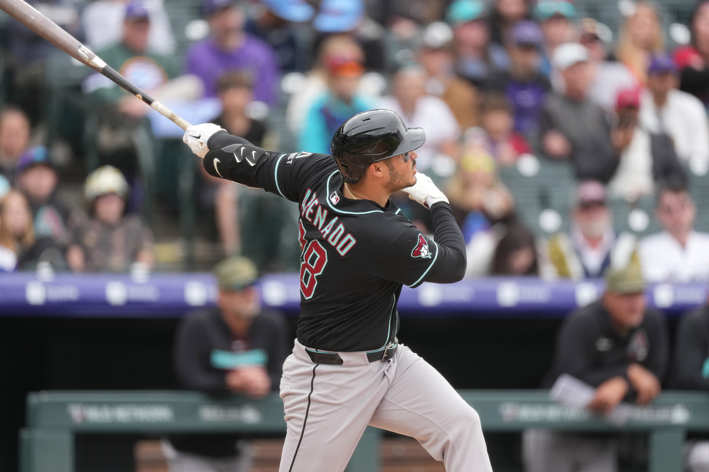 Arizona Diamondbacks' Nolan Arenado follows the flight of his RBI single off Colorado Rockies starting pitcher Michael Lorenzen in the third inning of a baseball game, Sunday, May 17, 2026, in Denver. (AP Photo/David Zalubowski)